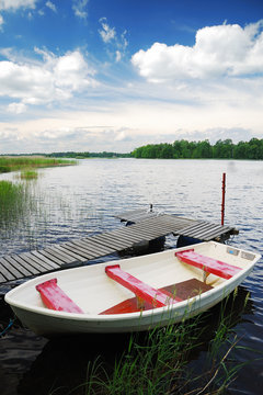 Swedish lake with small wooden wharf and boat