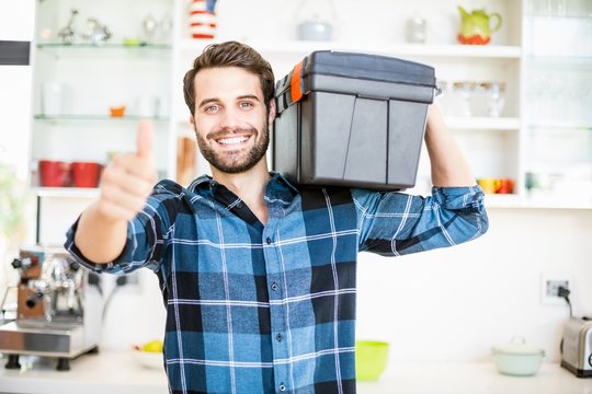 Man Carrying Tool Box Giving Thumbs Up