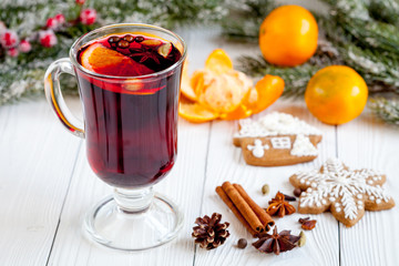 Christmas mulled wine with spices in cup on wooden background