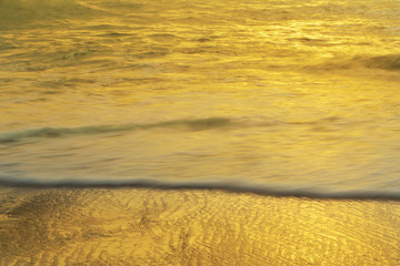 Fototapeta na wymiar Gold sea water at sunset reflect background