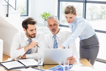 Obraz premium Business colleagues discussing office work on laptop