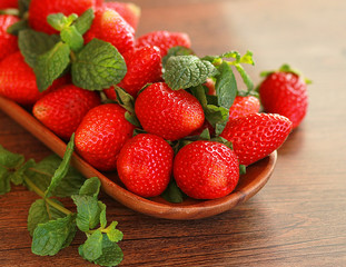 strawberries on a wooden plate on a wooden background