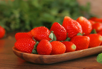 strawberries on a wooden plate on a wooden background