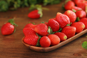 strawberries on a wooden plate on a wooden background