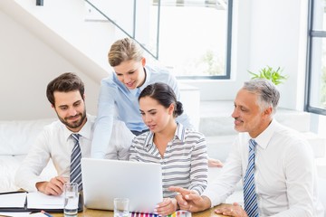 Business colleagues discussing office work on laptop