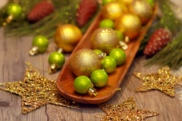 red green and gold Christmas balls on wooden tray, golden stars