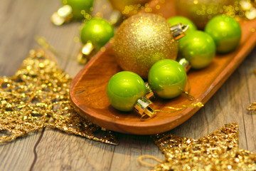 red green and gold Christmas balls on wooden tray, golden stars