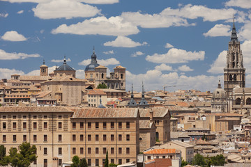 Skyline of Toledo with the Toledo Cathedral and other medieval houses on a blue sky filled with clouds 