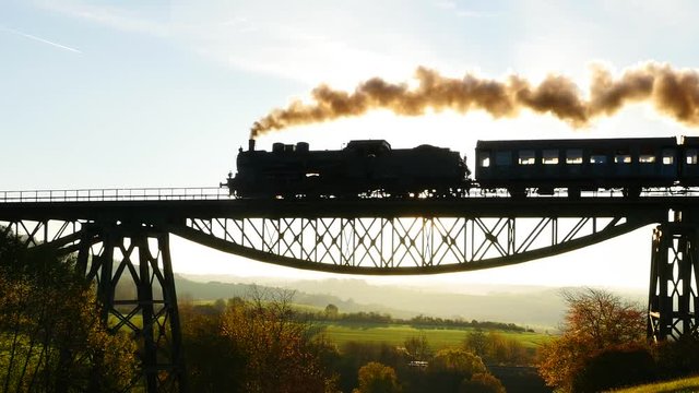 beautiful nostalgic view of steam locomotive train silhouette at sunset sky.