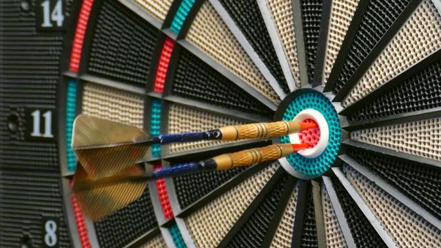 Three darts hit the double bullseye in rapid succession.
