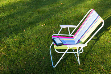 e-Book reader on the chair, green grass background