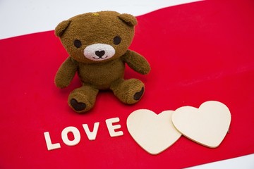 Bear with wooden heart on red background