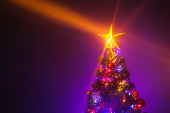 Christmas tree with shining star and dense mist