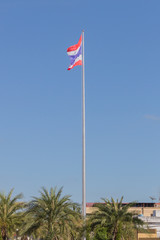 Image of waving Thai flag of Thailand with blue sky background.