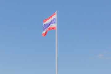 Image of waving Thai flag of Thailand with blue sky background.