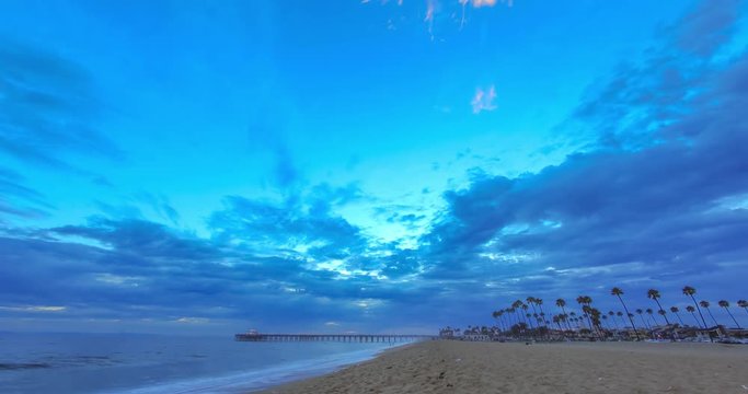 Sunset time lapse at the Newport Beach Pier at the beach with moving clouds and colors in the sky