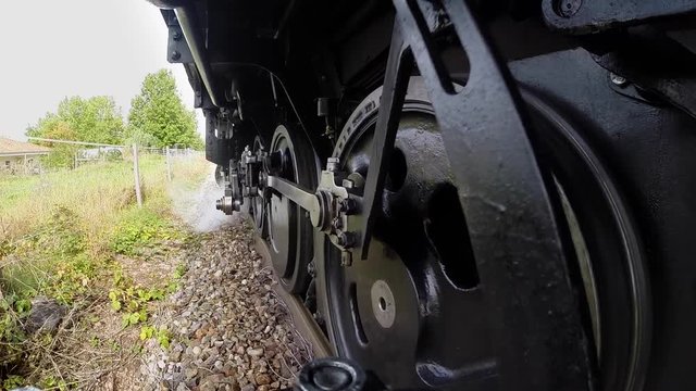 camera mounted onboard of steam train locomotive. steel wheels background.