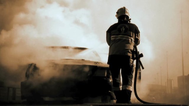 firefighter deleting Burning car background. demolition sabotage.
