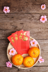 Basket of mandarin oranges with Chinese new year red packets
