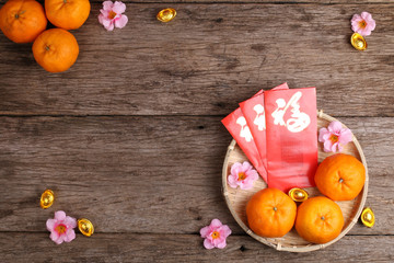 Basket of mandarin oranges with Chinese new year red packets