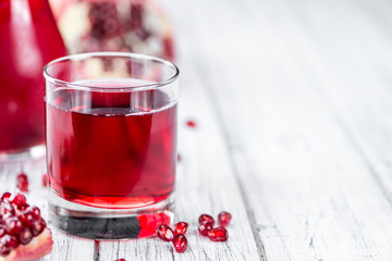 Fresh made Pomegranate juice on rustic background