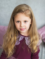 Portrait of pretty little girl in a lilac dress