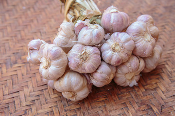 Garlic bulbs with garlic cloves on the vintage wicker or basketwork.