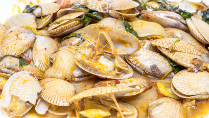 Closeup to stir fried clams with roasted chili paste and thai basil leaf.