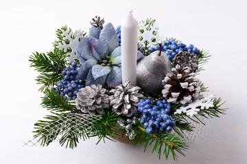 Christmas table centerpiece with candle and blue silk poinsettia