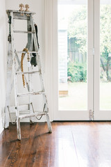 Vintage decor of an old ladder, farm bell and rope light