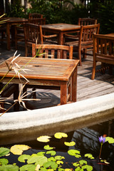 Outdoor cafe patio with old, shabby wooden tables and chairs 
