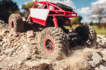 Rc suv pulling through rocky landscape. Small crawler riding on dry mountain road. Extreme sport, adventure, leisure concept