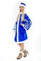 The Snow Maiden in blue Christmas costume. Beautiful white girl with long blond hair. On her feet wearing suede brown boots. Makeup on the face and blue nails. Isolated on white background.