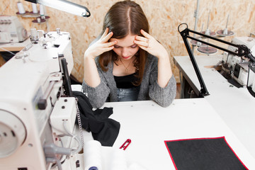 Seamstress realized she made mistake, copy space. Tired frustrated tailor sitting in stress,...