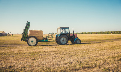 Fototapeta na wymiar Трактор на осеннем поле. Сбор урожая