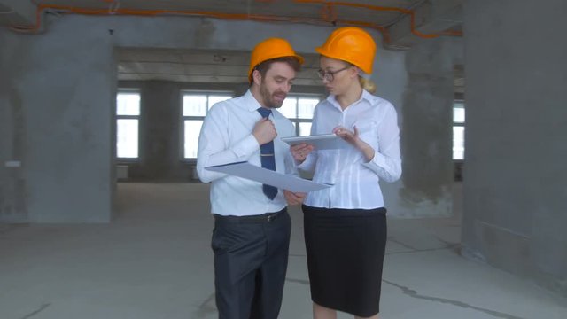 Architect and investor, businesspeople checking new building inder construction. Smooth camera movement, steadycam shot. 4K.