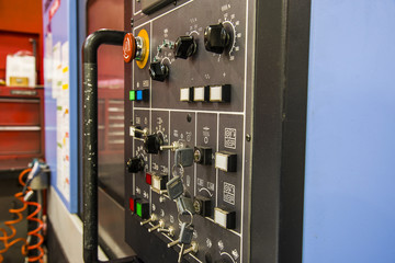 Modern CNC machining center with control panel on foreground. Close up view. Selective focus.