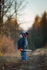 Young boy playing outdoor with wooden sword