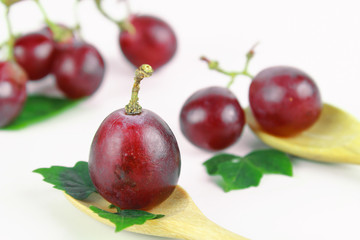 Ripe red grape with leaves isolated on white