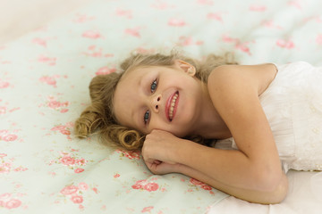Obraz na płótnie Canvas Pretty smiling little girl woke up in the morning in bed