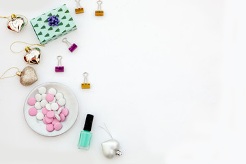 flat lay on white.Femnine workspace with nail polish, gift, candies, clips.Christmas concepts