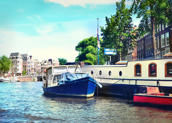 Amsterdam city scene of the Amstel river and anchored boats.