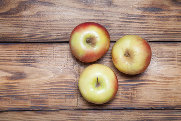 Yellow-red seasonal apples on the background of burned boards