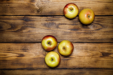 Yellow-red seasonal apples on the background of burned boards. T
