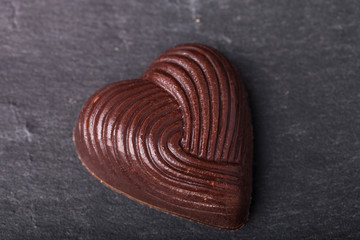 One chocolate candy on a slate background