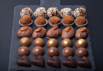 Different kinds of chocolate candies on a slate background