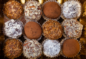 Set of different kinds of homemade chocolate truffles in a golde