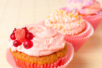 sweet cupcakes with cream and currants