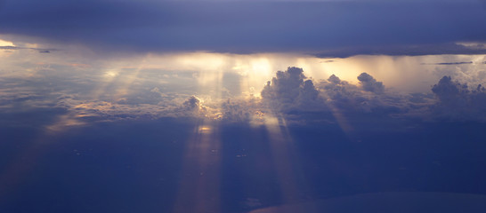 Light rays sunset shining through rich in space clouds,panorama