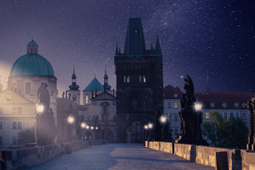 Prague, Czech Republic. Charles Bridge with its statuette at night, Old Town Bridge Tower in the...